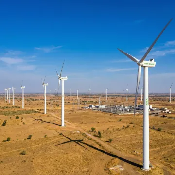 Utility-scale wind turbines operating across an Indian industrial landscape