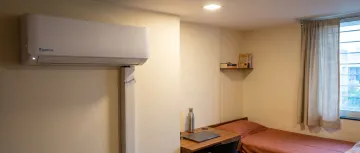 Hostel room with split AC unit installed