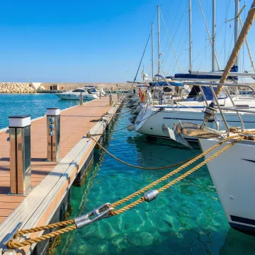 Heavy-duty mooring lines securing commercial vessels at a marina dock