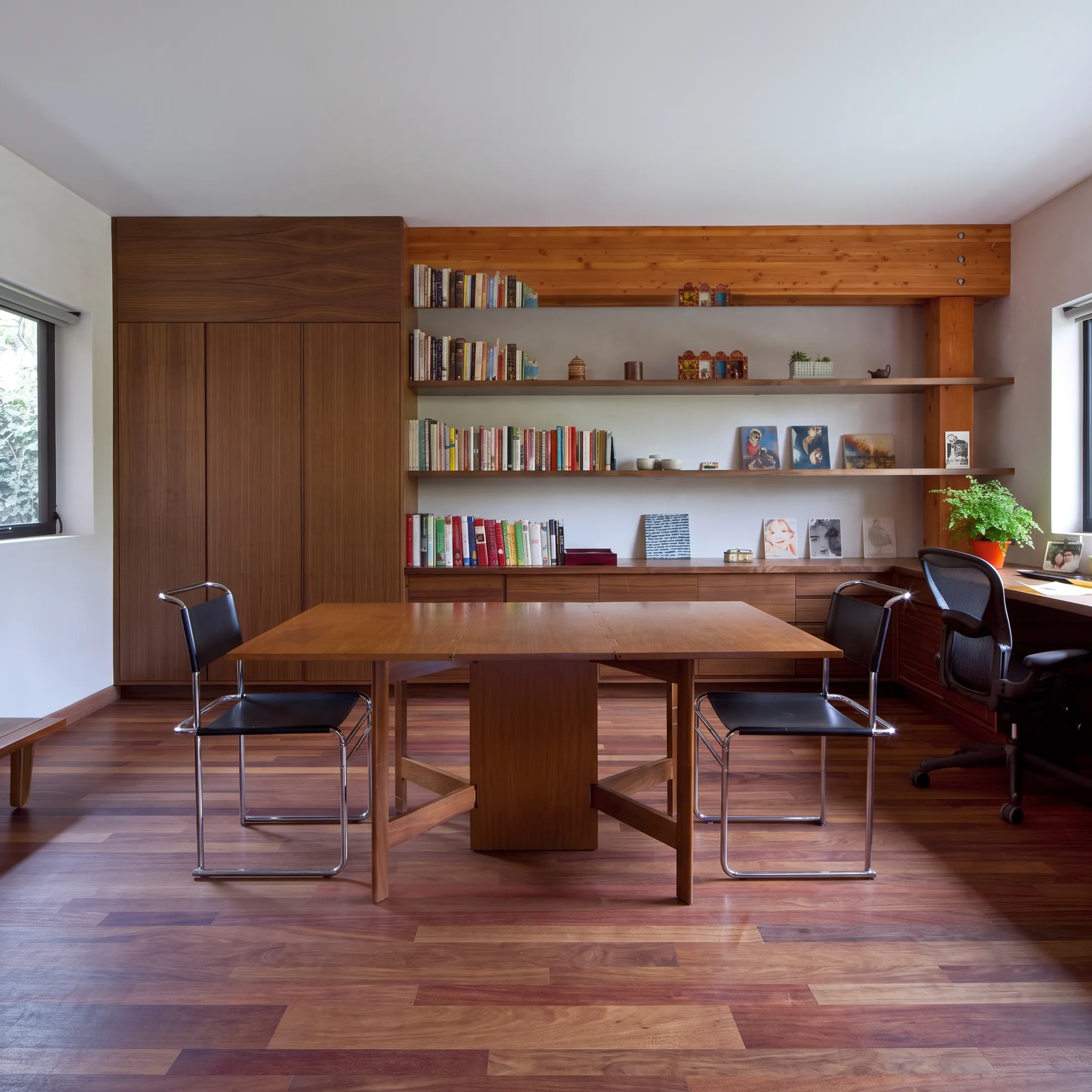 Elegant custom home office with built-ins, refined furniture, and natural light