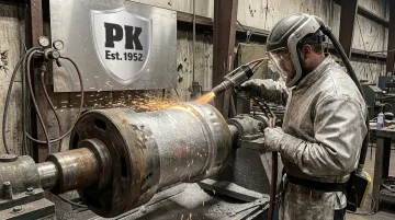 Worker applying thermal spray coating restoration on industrial steel component