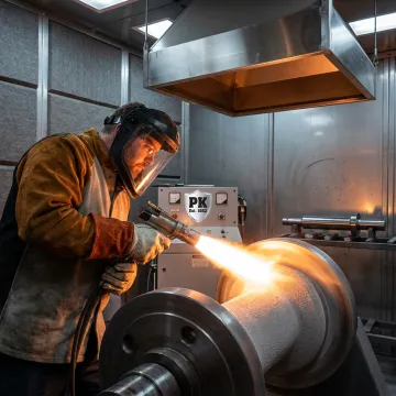 Technician applying industrial ceramic coating to metal component