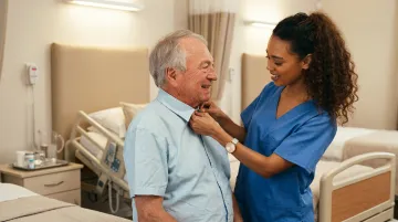 Long-term care nurse assisting elderly resident with mobility in nursing home