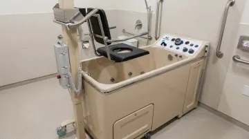 Healthcare therapeutic bathing system with height-adjustable transfer mechanism and disinfection controls