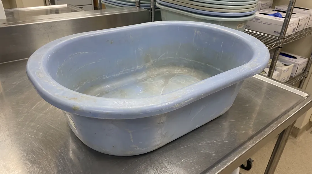 Reusable hospital bath basin showing visible bacterial contamination risk