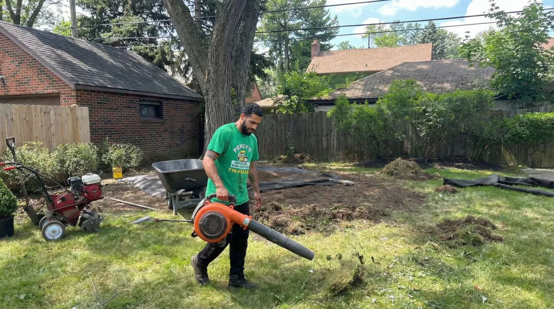 Lawn care professional applying eco-friendly treatment to Buffalo residential yard