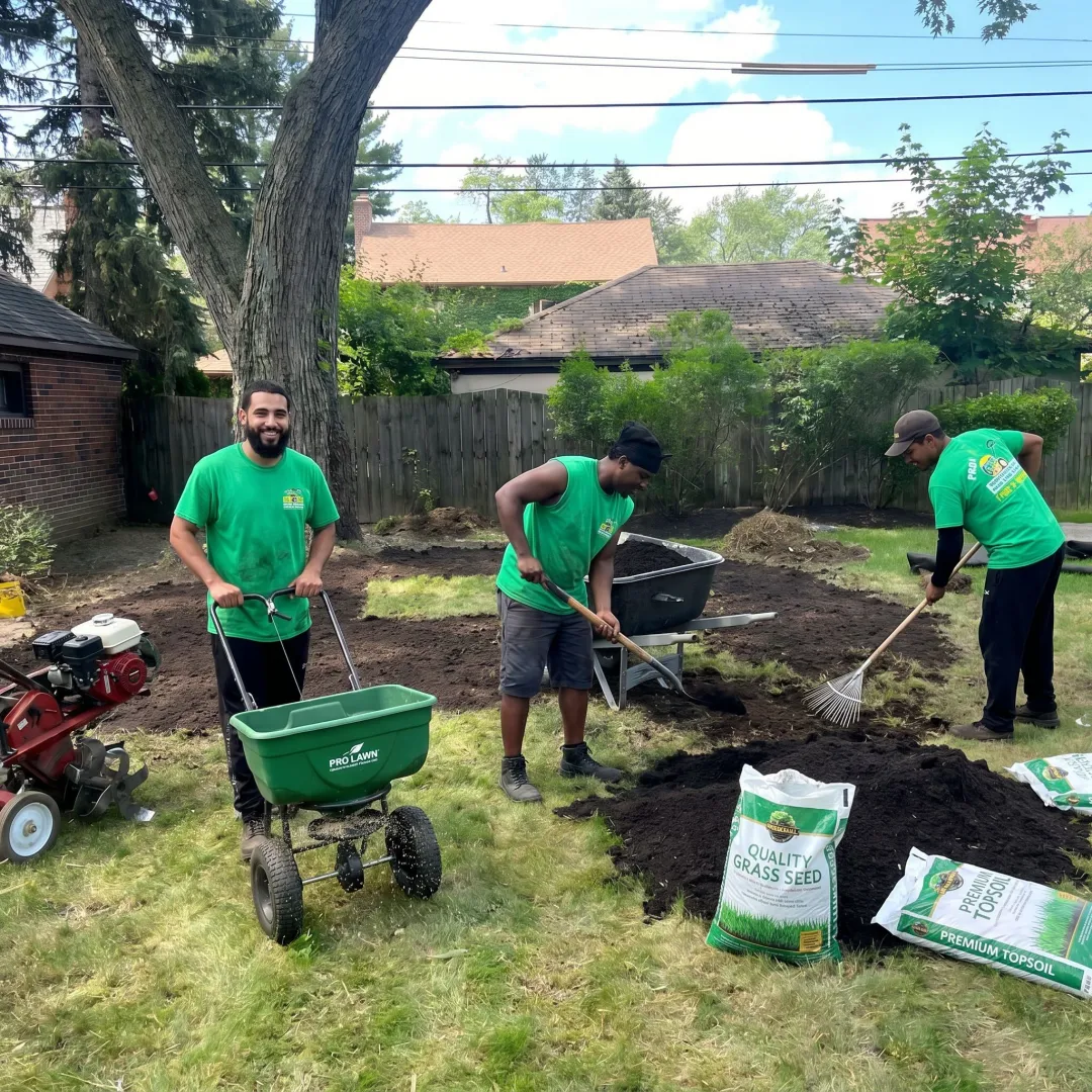 Contractor restoring patchy lawn with seed and soil