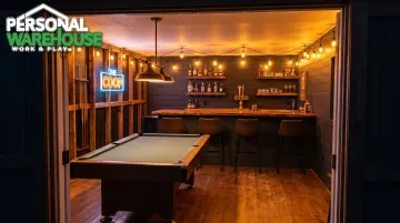 Rustic backyard shed bar interior with pool table string lights and bar counter