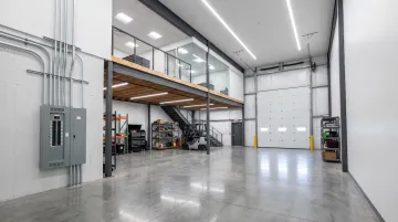 Personal Warehouse unit interior showing mezzanine LED lighting and overhead door upgrades