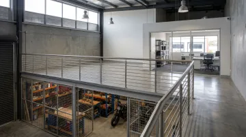 Warehouse mezzanine office level with steel railings overlooking open floor below