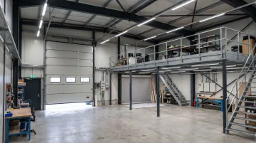 Personal Warehouse studio unit interior showing mezzanine three-phase electrical and overhead doors