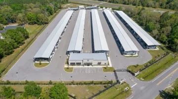Large-scale institutional RV storage facility with rows of enclosed units and gated access