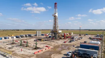 Natural gas drilling rig and production wells at oil field site