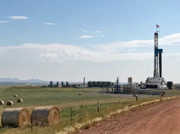 Natural gas drilling rig and production wells in rural development site