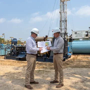 Energy professionals reviewing Texas well data