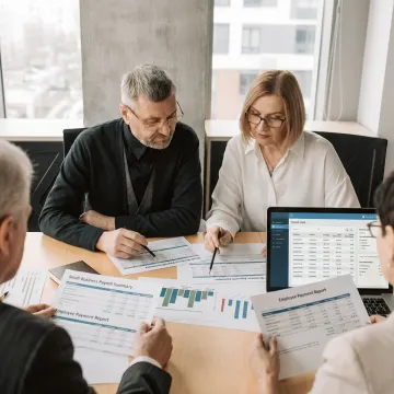 Small-business owner reviewing payroll with an advisor