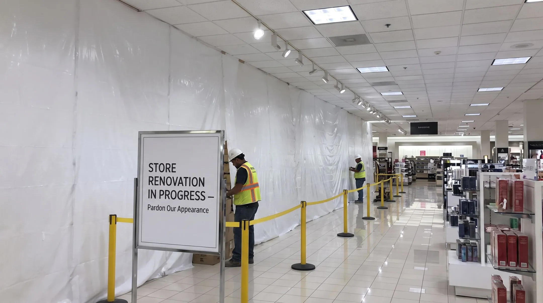 Occupied retail store undergoing phased renovation with construction barriers