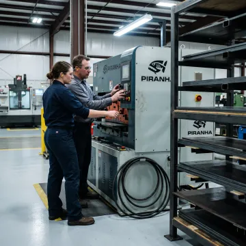 Fabrication team reviewing metalworking machinery