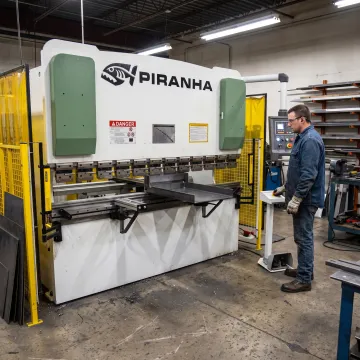 Industrial hydraulic press operating in a metal fabrication shop