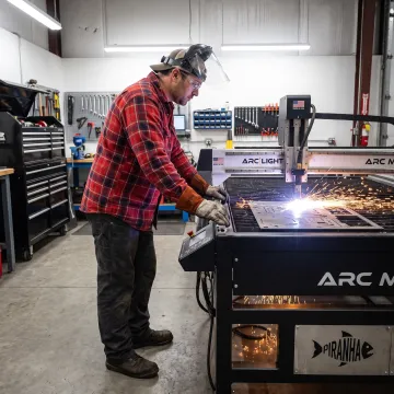 Operator using a portable CNC plasma cutter