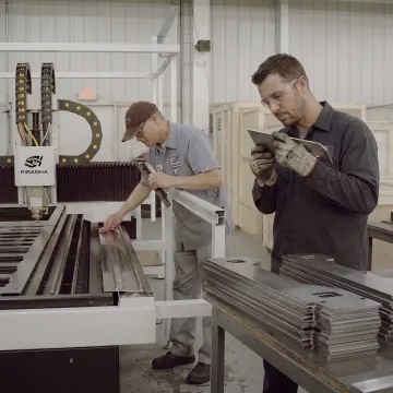 Fiber laser operator reviewing cut parts