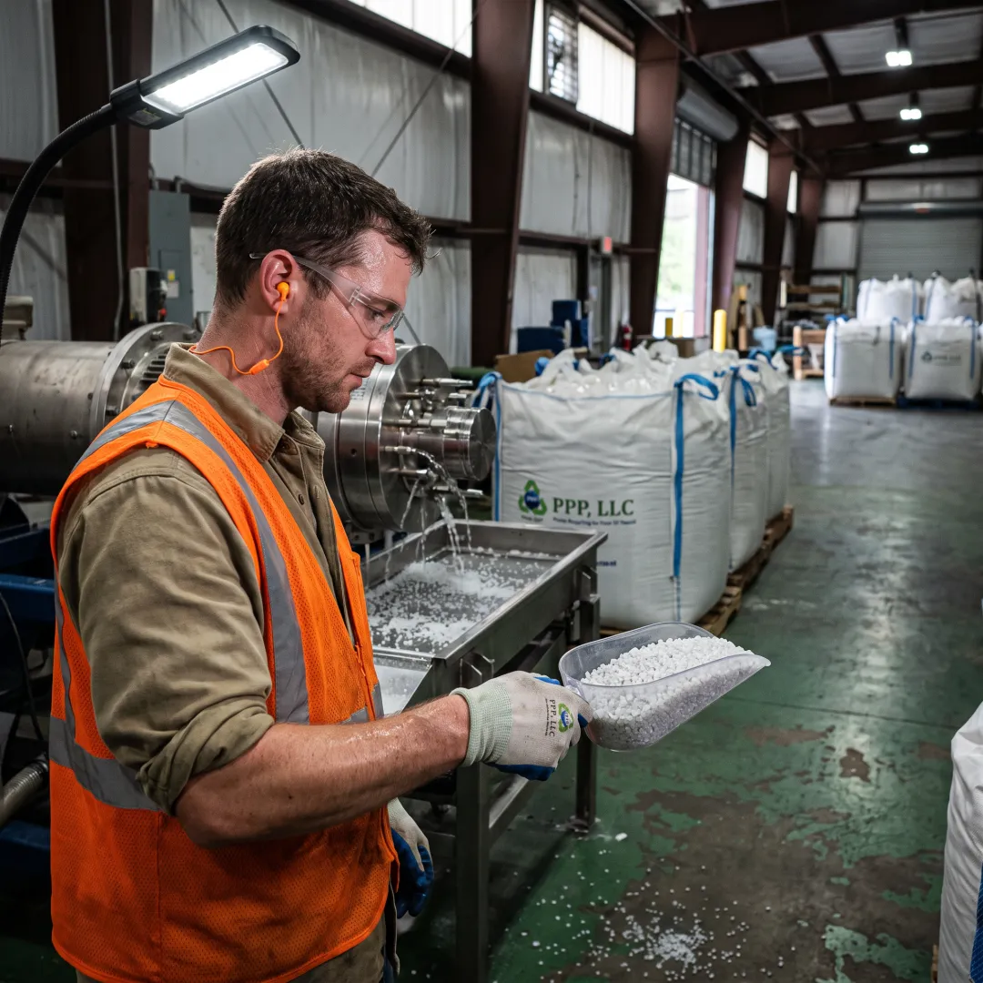 Technician inspecting recycled plastic pellets