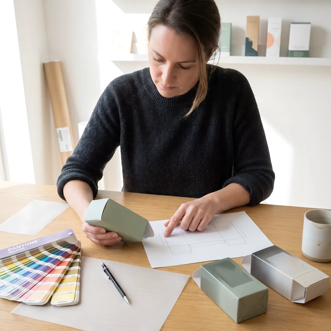 Designer reviewing custom wellness packaging samples