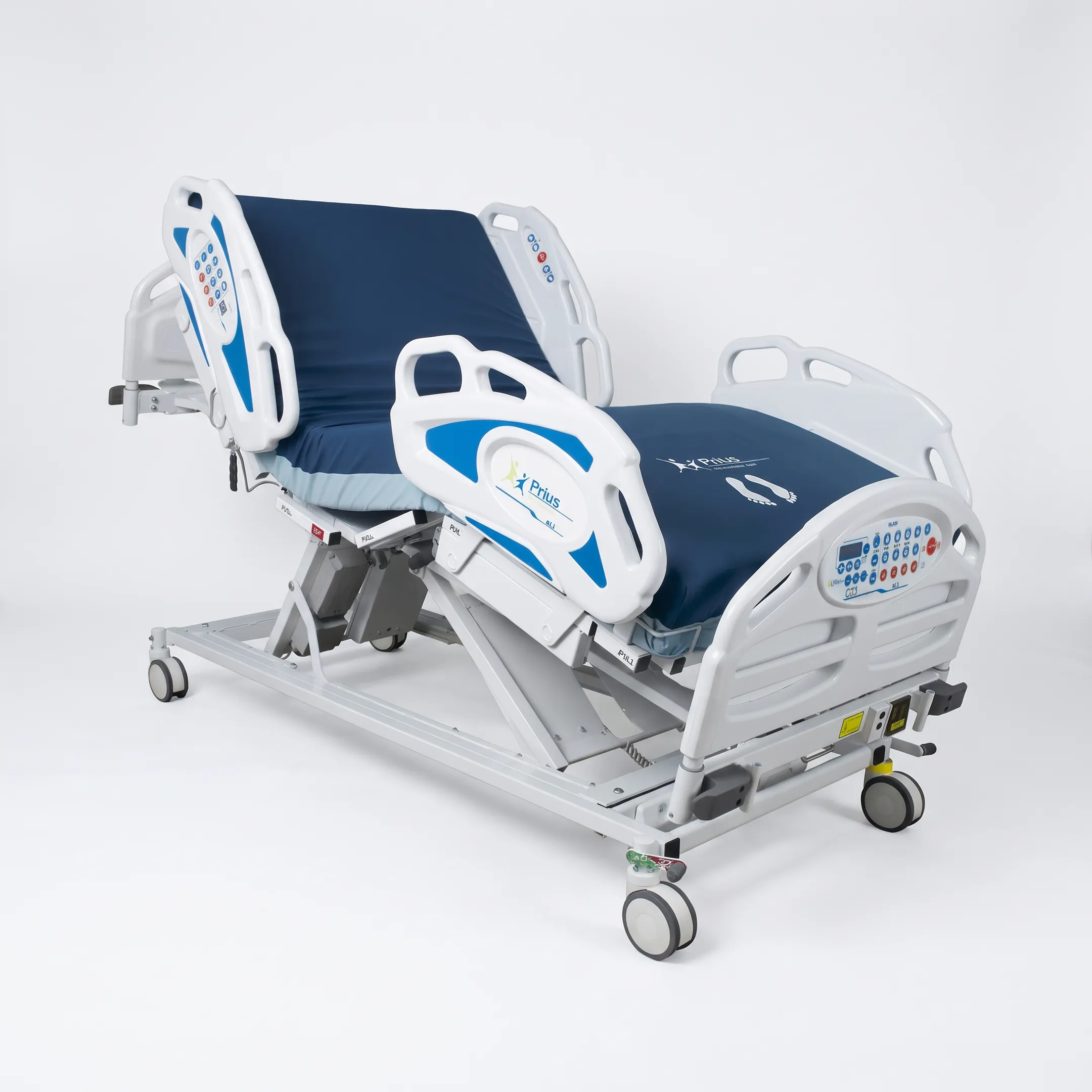 Caregiver adjusting a hospital bed beside a patient on a therapeutic mattress