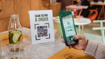 Restaurant QR code payment system showing customer scanning table code on smartphone