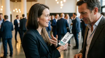 Two professionals naturally exchanging digital contact details at networking event