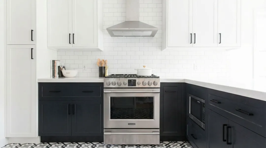 Two-tone kitchen with white upper cabinets black hardware and dark lower cabinets