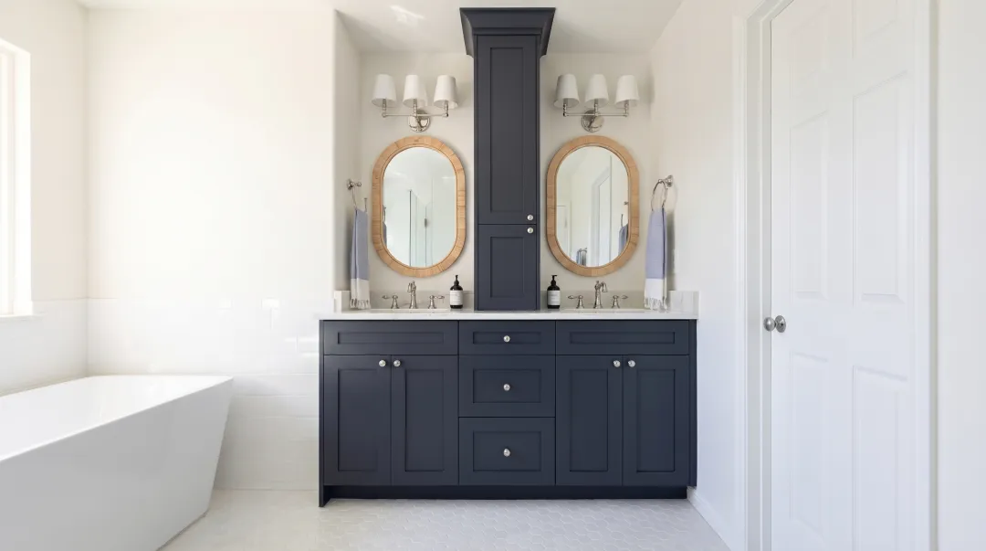 Spacious primary bathroom with separate dual vanity units flanking central storage tower
