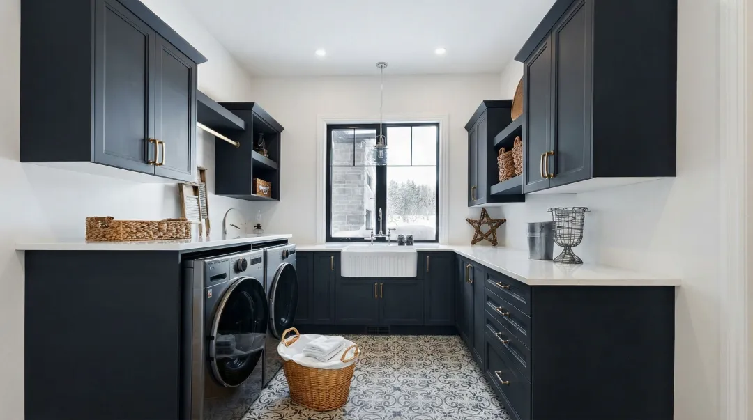 Bold dark charcoal laundry room cabinets with white walls and quartz countertops