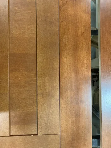 Craftsman measuring and installing custom cabinets in a residential kitchen.