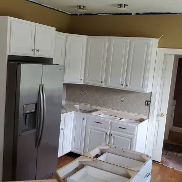 Cabinet installation process showing a craftsman fitting custom kitchen cabinets