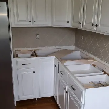 Cabinet maker measuring and installing a custom bathroom vanity with mirror