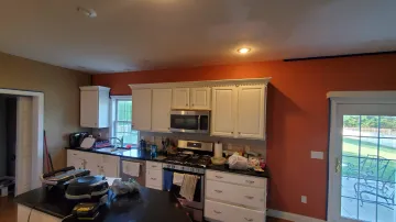 Cabinet maker installing custom wood cabinets during home renovation