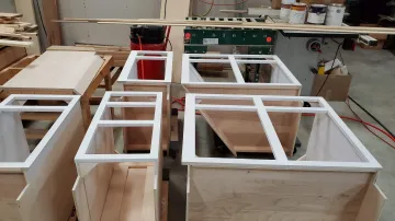 Cabinet maker measuring and installing custom cabinetry in a home