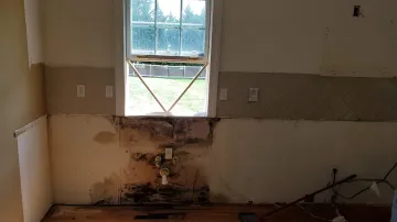 Cabinet maker measuring and installing flat panel European kitchen cabinets