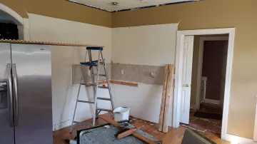 Custom cabinet installation process with a craftsman fitting kitchen cabinetry
