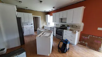 Cabinet maker measuring and planning a custom kitchen cabinet installation