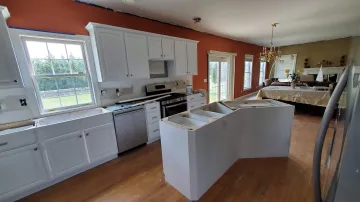 Custom cabinet maker measuring kitchen space during a design consultation visit