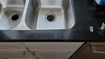 Cabinet maker measuring and installing custom kitchen cabinets