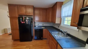 Craftsman measuring and installing custom cabinet with precision tools