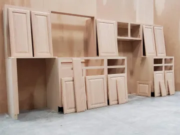 Skilled cabinet maker measuring and installing custom kitchen cabinets