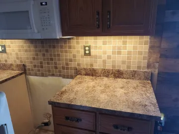 Cabinet craftsman measuring and installing custom kitchen cabinets