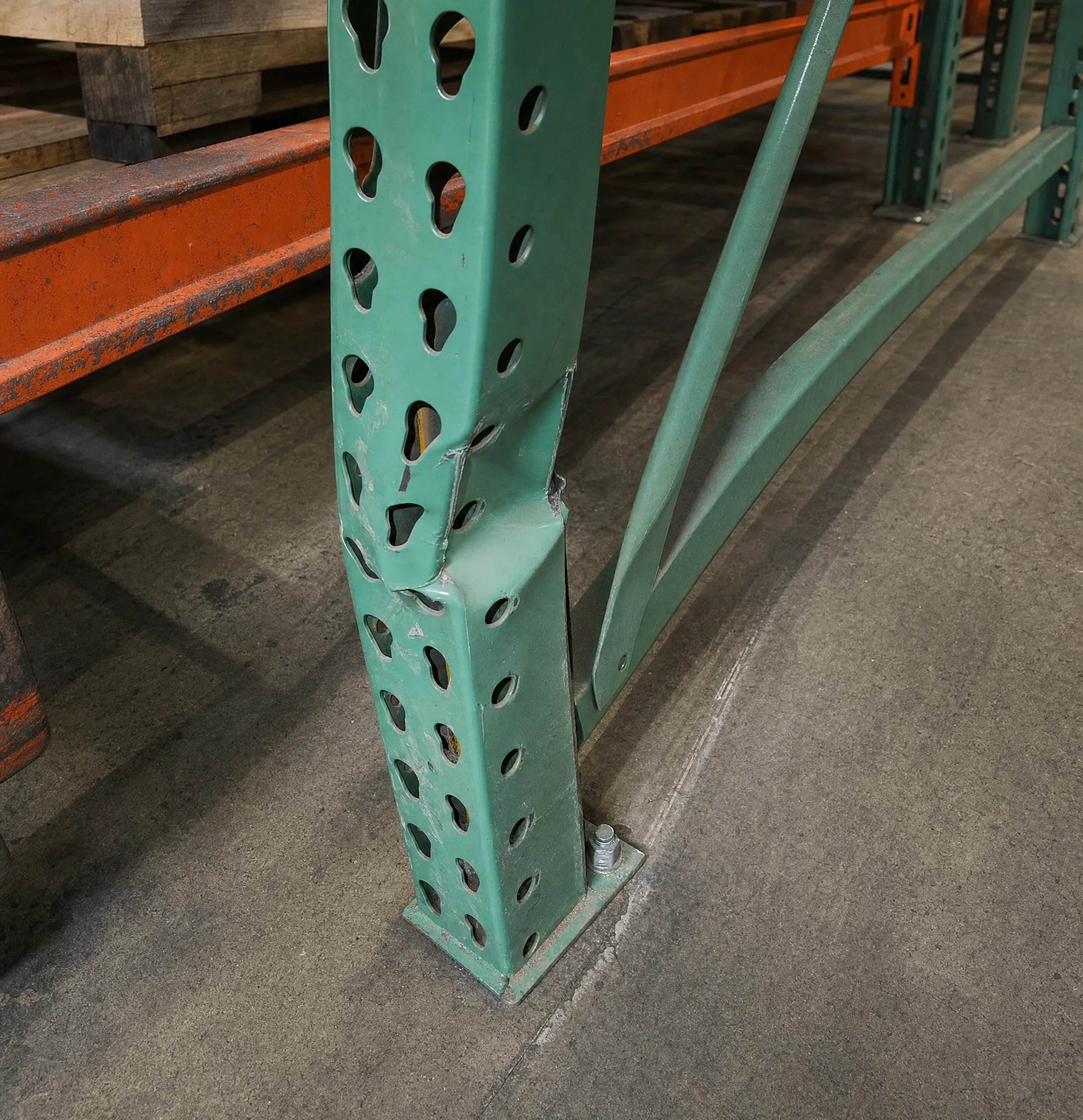 Damaged warehouse pallet racking with bent frame and forklift impact