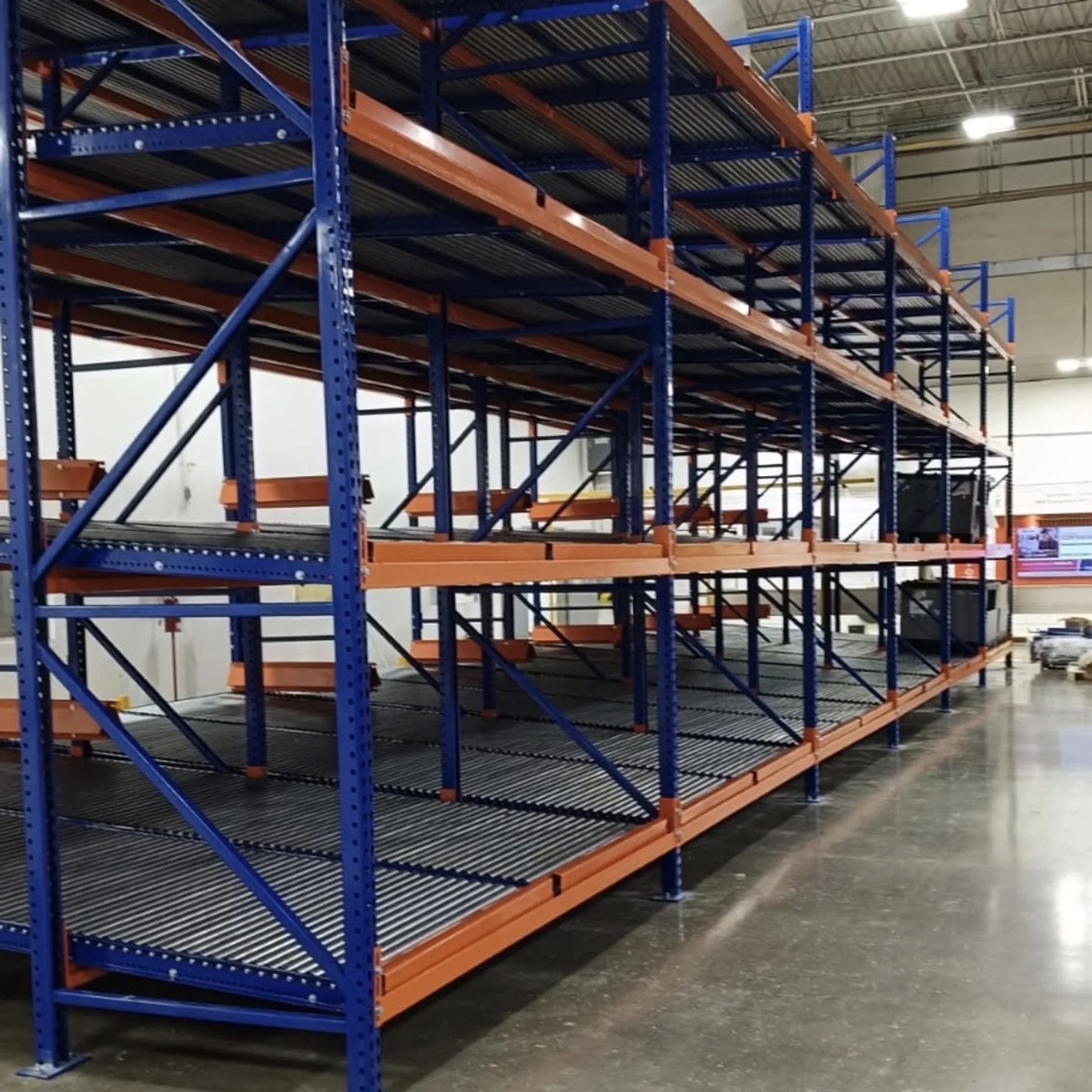 Warehouse worker inspecting pallet flow rollers