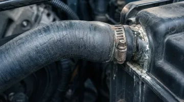 Close-up of cracked deteriorated radiator hose showing rubber aging and surface crazing