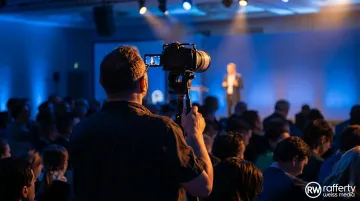 Professional corporate event photographer capturing keynote speaker on stage at conference